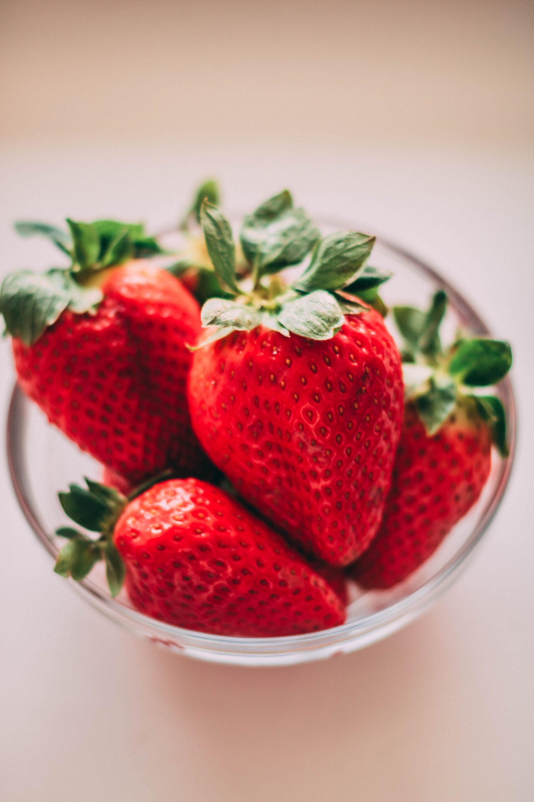 Bright red strawberries in a clear glass bowl