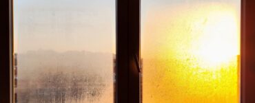 Two small frosted window panes with an orange sunrise glowing through one