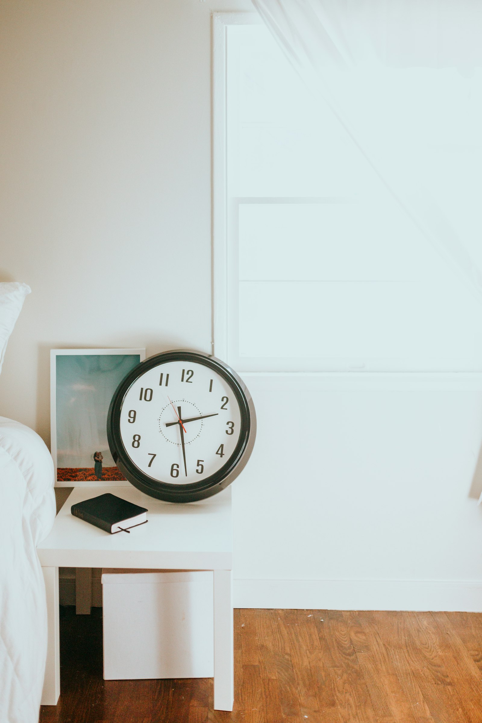 Black and white round analog wall clock showing ten o'clock