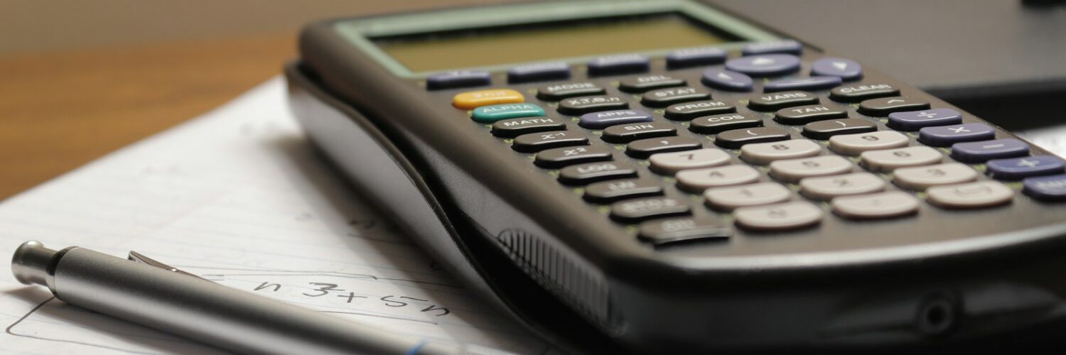 A calculator and a pen resting on a sheet of paper