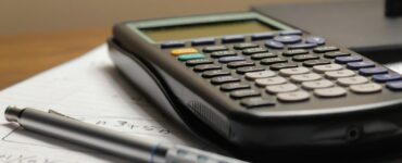 A calculator and a pen resting on a sheet of paper