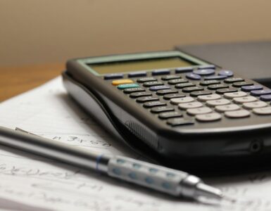 A calculator and a pen resting on a sheet of paper