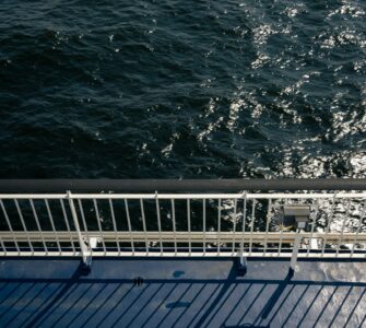 A ship's rail overlooking dark, sparkling ocean water