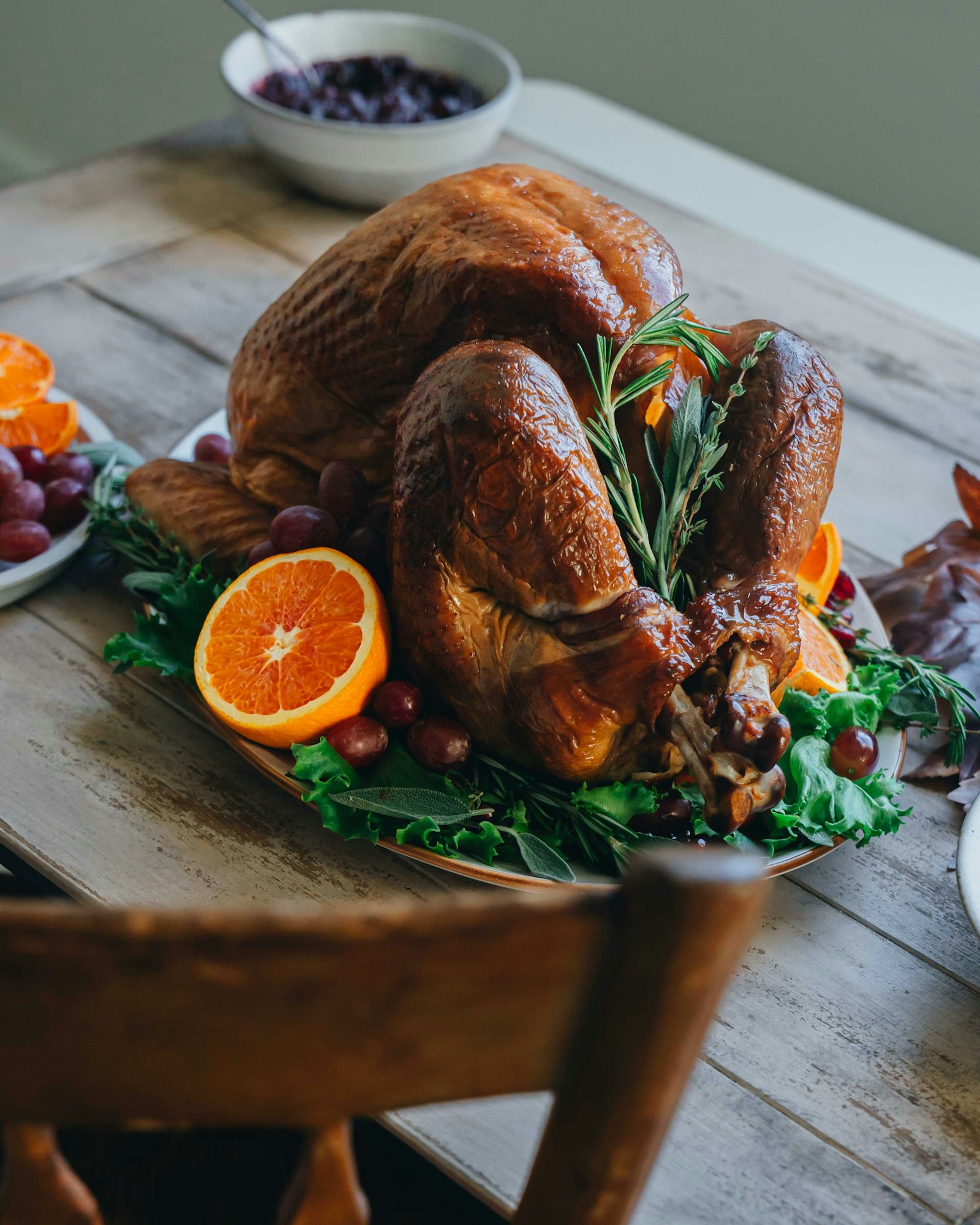 A golden roasted turkey garnished with orange slices and rosemary