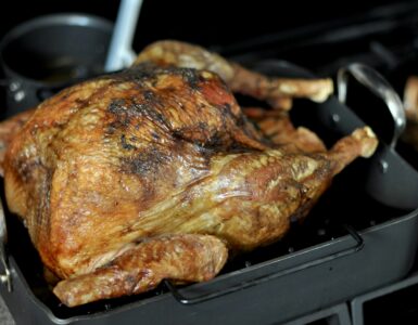 A golden-brown roasted turkey in a roasting pan